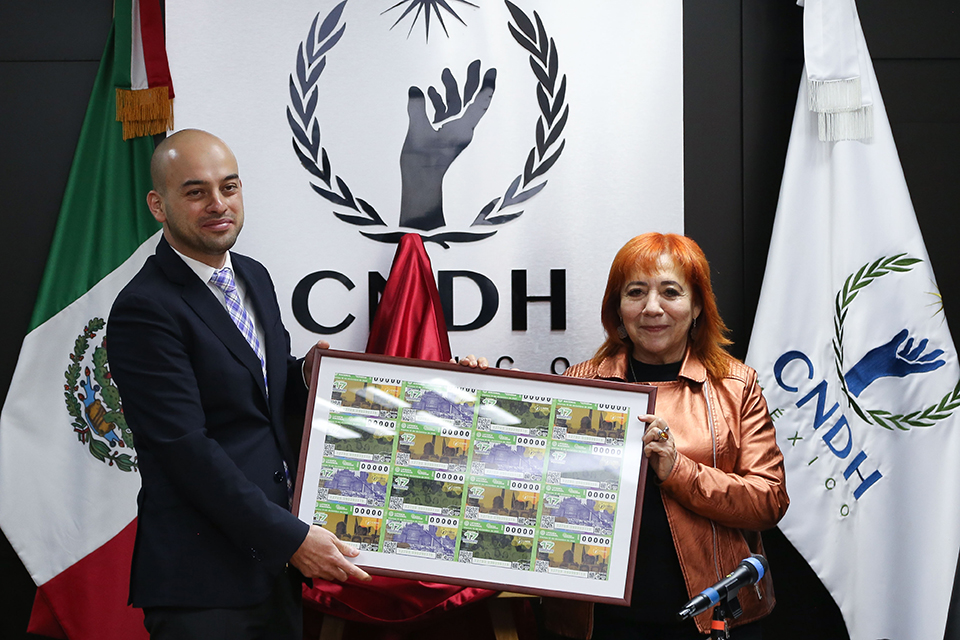 La presidenta de la CNDH, Rosario Piedra Ibarra y el subdirector General Jurídico de la Lotería Nacional, Edgar Antonio Maldonado Ceballos, develaron el billete conmemorativo del Día Internacional de los DDHH 